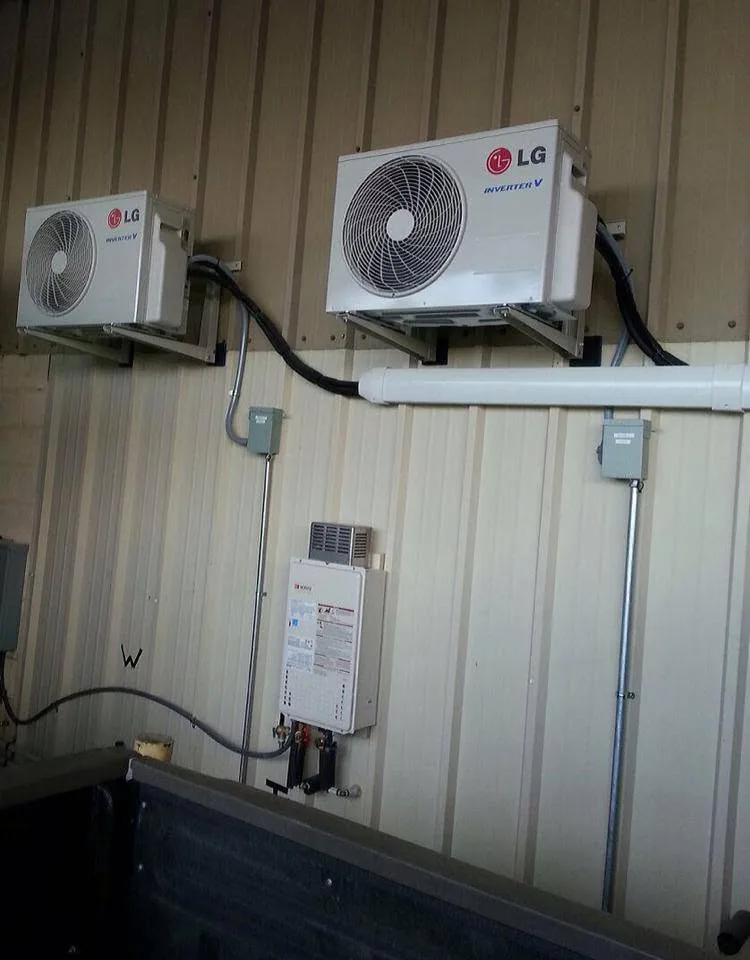 Two ductless mini-split outdoor units installed on a metal building
